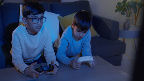 Zwei-Junge-Jungs-Spielen-Zu-Hause-Spät-In-Der-Nacht-Mit-Einer-Computerspielkonsole-Im-Fernsehen-Und-Halten-Controller-In-Der-Hand-3